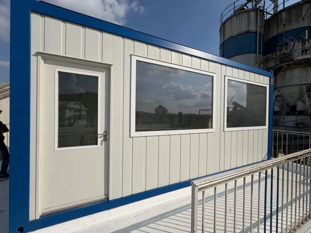 Bürocontainer 20 ft der CLASSIC Line mit großer Fixverglasung und Glastür auf einem Industriegelände