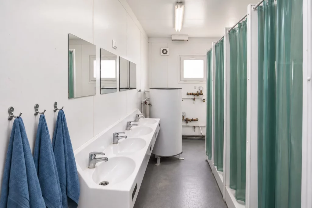 Waschraum eines aufbereiteten gebrauchten Sanitärcontainers mit Waschrinne und Duschen