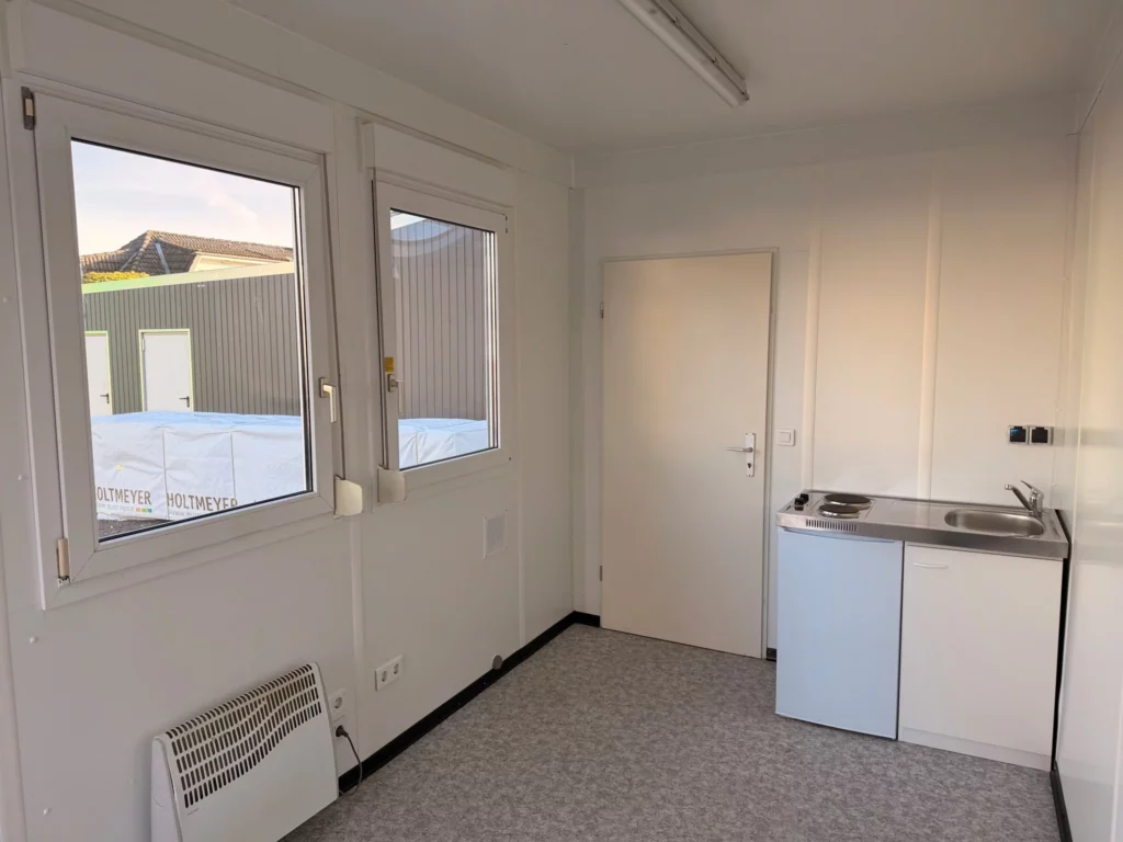 Fertiger Büroraum mit zwei Fenstern, Konvektor, Innentür und Küchenblock