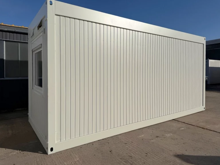 Gebrauchter Bürocontainer 20 ft in Reinweiß, Schrägansicht mit Längsseite und Fenster an der Stirnseite.