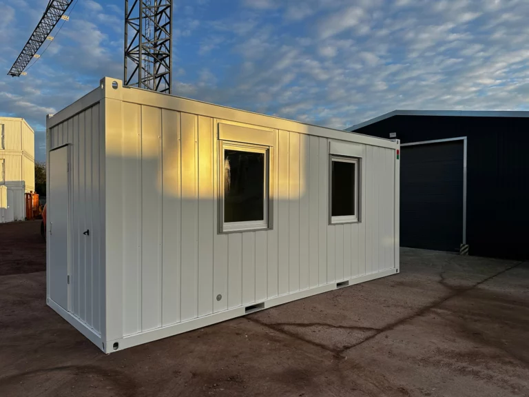 Bürocontainer 20 ft in der Schrägansicht mit zwei Fenstern an der Längsseite und der Eingangstür an der Stirnseite.